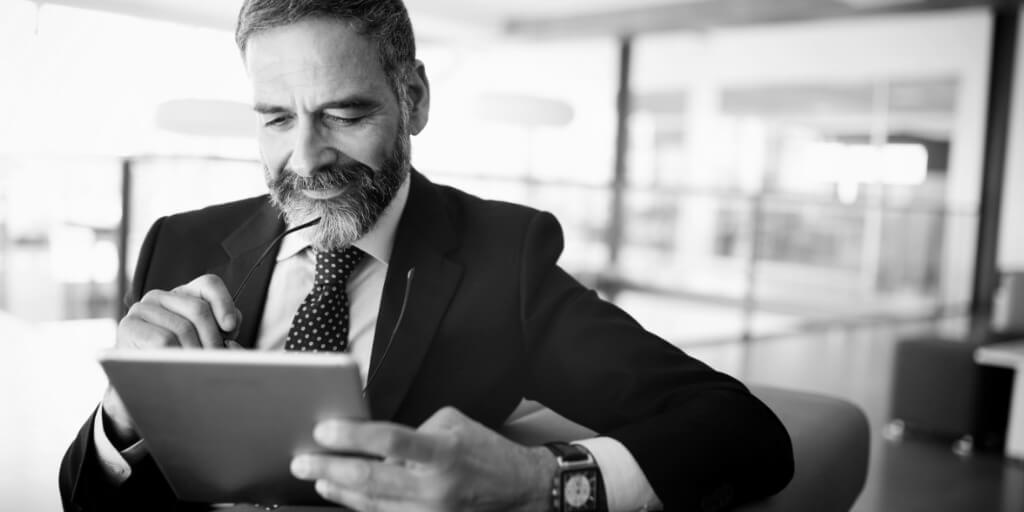 A business professional reviewing information on a tablet in an office setting.
