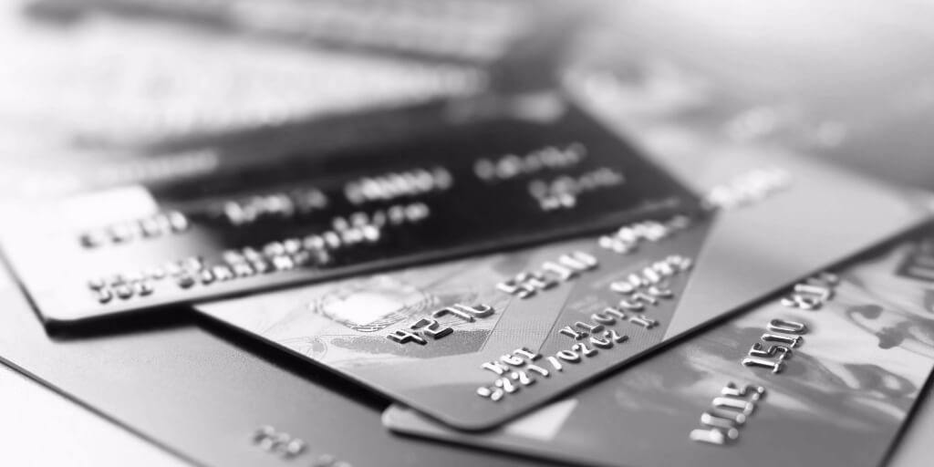 Credit cards are stacked in disarray, extending out of sight.